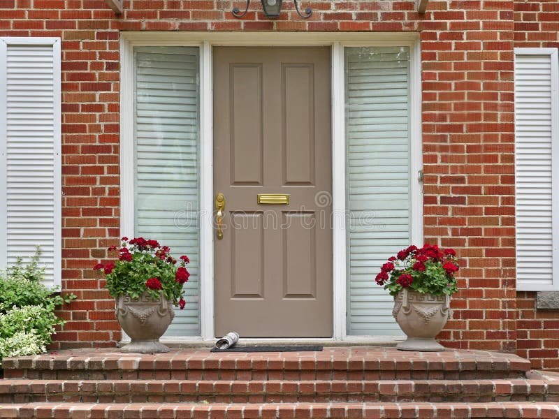 Front door. With newspaper and pots of geraniums stock images